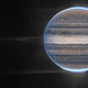 Jupiter’s faint rings and two of its moons can be seen against a backdrop of distant galaxies.
